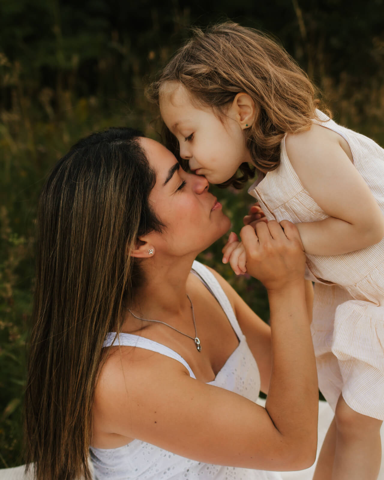 mommy & me Fotoshootings in münchen. mutter mit ihrer 3jährigen Tochter in münchen Riemer Park. Tochter küsst Mutter auf die Stirn.